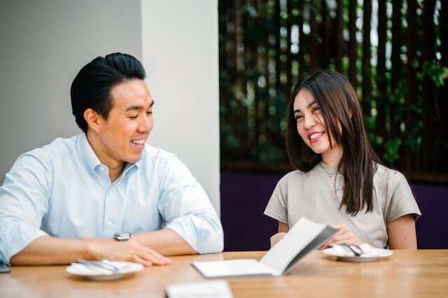 Couple sitting at desk discussing the Australia Government extending visa and PR options for Hong Kong Citizens in Australia