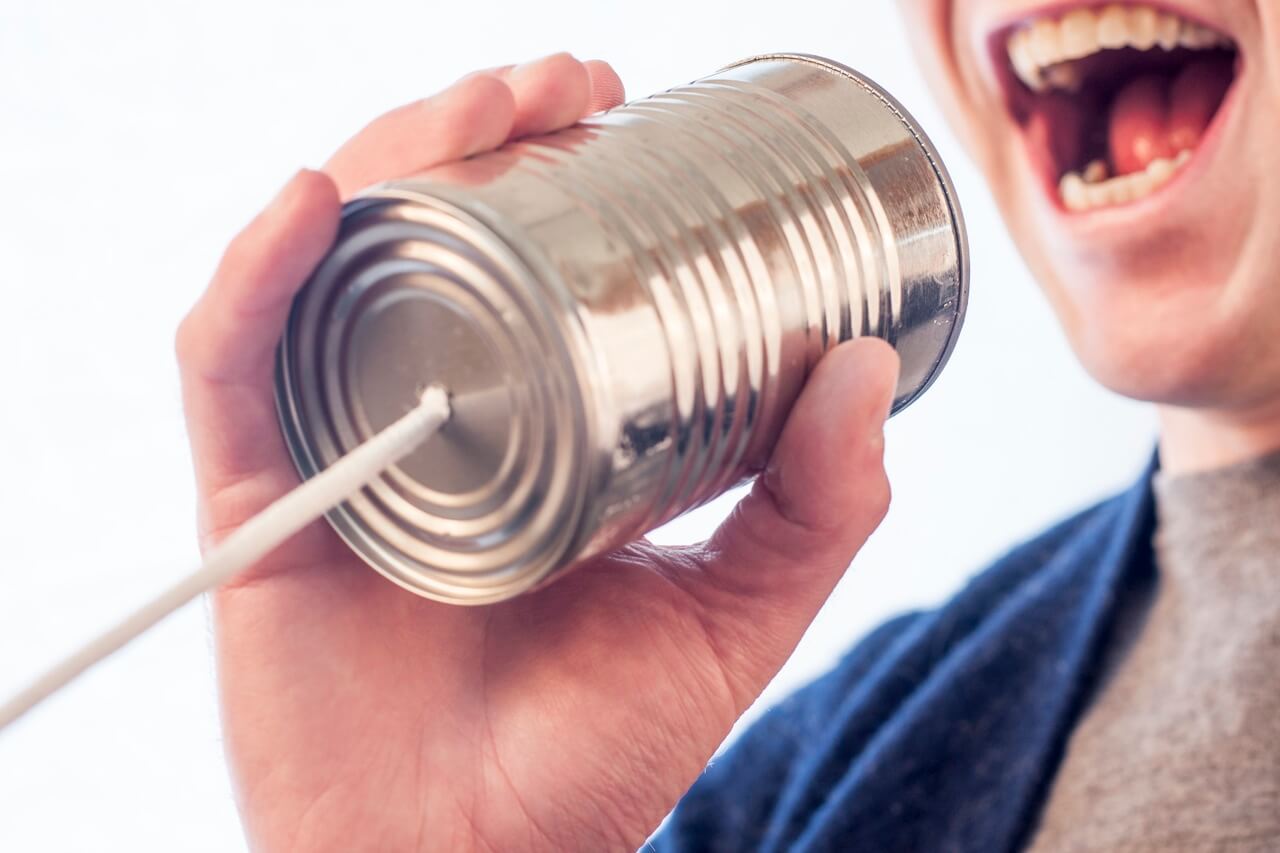 Man talking into tin can to represent marketing amplification