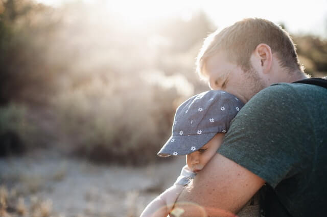 Young father hugging his child, happy about permanent residence in Australia