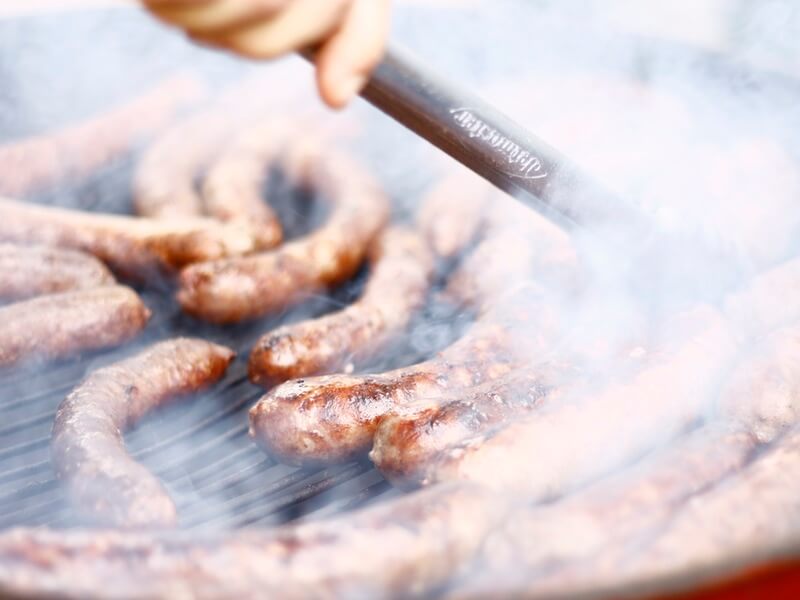 Sausages being cooked on BBQ grill